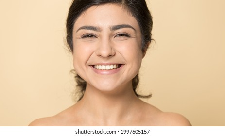 Close Up Portrait Of Smiling Indian Woman Isolated On Yellow Studio Background Show Healthy Glowing Face Skin After Treatment Procedures. Happy Mixed Race Female With White Teeth. Skincare Concept.