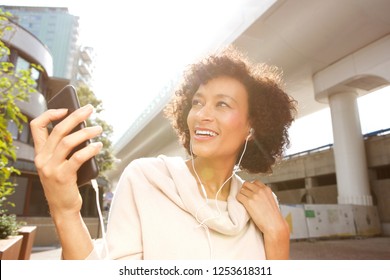 Close Up Portrait Of Smiling Older Woman Listening To Music With Headphones And Smart Phone