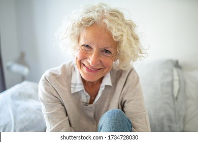 Close up portrait smiling older woman relaxing at home