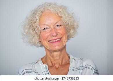 Close up portrait smiling older woman against white background 