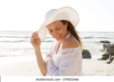 Close Up Portrait Of A Smiling Older Woman With Hat At The Beach 