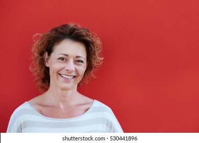 Close Up Portrait Of Smiling Older Woman Against Red Background