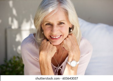 Close Up Portrait Of Smiling Older Woman With Hand In Hands Outside