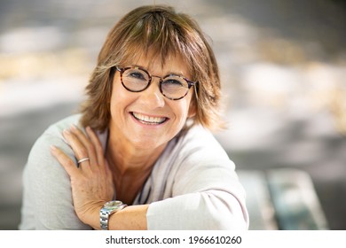 Close Up Portrait Smiling Woman With Eyeglasses Sitting Outside