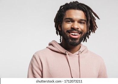 Close up portrait of a smiling young african man wearing hoodie standing isolated over white background, looking at camera