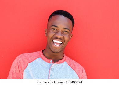 Close up portrait of smiling young african american man against red background