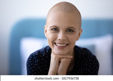 Close up portrait of smiling young hairless woman beat cancer look at camera happy with remission. Positive bald female patient with oncology feel optimistic about sickness recovery, good results.