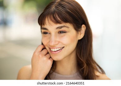 Close Up Portrait Of Smiling Young Woman With Short Brown Hair Looking Away Outside