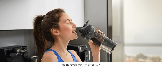 Close up portrait of sportswoman face, fitness girl drinks water from sport bottle and smiling, hydrating after productive aerobics, yoga workout. - Powered by Shutterstock