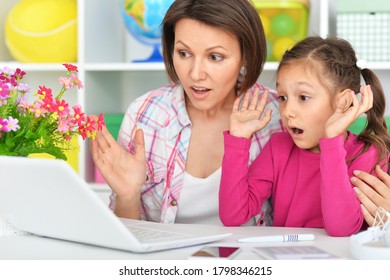 Close Up Portrait Of Suprised Mother And Daughter Using Laptop Together