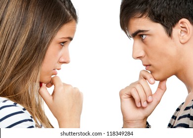 Close up portrait of teen couple looking at each other with wondering expression.Isolated on white.