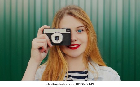 Close up portrait of teenager girl with retro camera