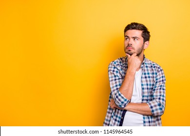 Close up portrait of thoughtful man who looks away touching his chin and weighs the pluses and minuses of the offer isolated on bright yellow background with copy space for text - Powered by Shutterstock