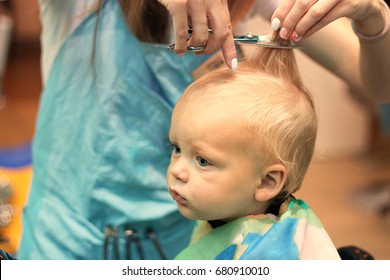 Close up portrait of toddler child getting his first haircut.