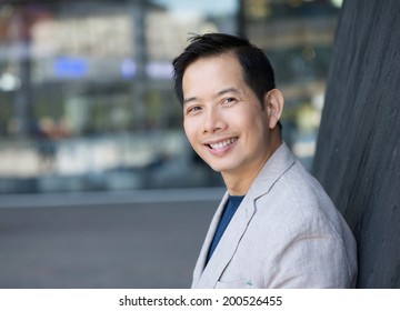 Close Up Portrait Of A Trendy Asian Man Smiling Outdoors