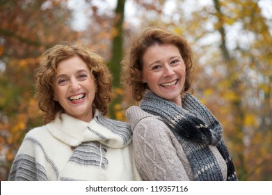 Close Up Portrait Of Two Mature Women Smiling In The Park