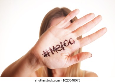 Close Up Portrait Of Unknown Young Woman Covering Her Face W/ #Metoo Hashtag Word On Palm Of Hand Isolated On White. Me Too Movement. Anti Sexism Protest Against Inappropriate Behavior Towards Women.