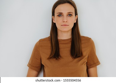 Close Up Portrait Of A Woman, No Emotion, Half Length. Front View. She's Of Middle Age, Casually Dressed, Wears Long Brown Hair Behind Ears And In Front Of Her Shoulders.