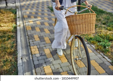 Close up portrait woman using ecological transportation by bike with basket while spending time in the picturesque sunlit avenue - Powered by Shutterstock