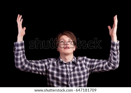 CLose up portrait of a young actor on black background. He is looking up in despair and panic. Look flabbergasted.