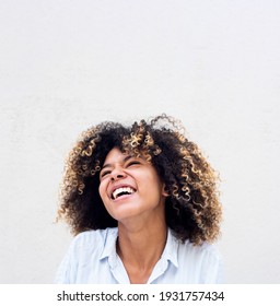Close up portrait young african american woman laughing against white background 