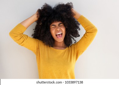 Close Up Portrait Of Young African Girl Screaming And Pulling Her Hair Against White Background