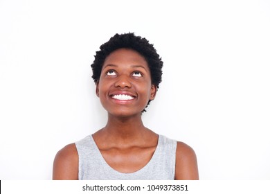 Close up portrait of young african woman looking up and smiling on white background