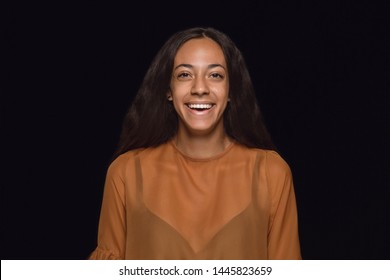 Close up portrait of young african-american woman isolated on black studio background. Photoshot of real emotions of female model. Facial expression, human nature. Smiling throught the tears.