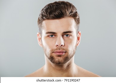 Close Up Portrait Of A Young Bearded Man Face Looking At Camera Isolated Over Gray Background