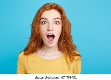 Close up Portrait young beautiful attractive redhair girl shocking with something. Blue Pastel Background. Copy space.