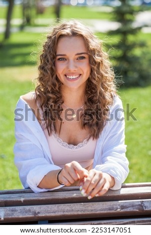 Close up portrait of a young beautiful blonde girl in summer park