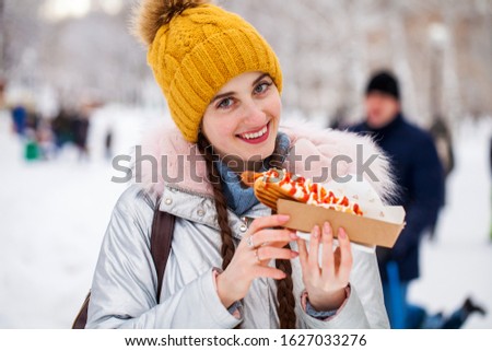 Close up portrait of a young beautiful brunette girl in winter park
