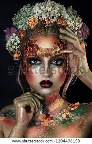 close up portrait of young beautiful girl with flower professional makeup. elf princess with flower crown on head.  Halloween makeup. bright face art. spring fairy of flowers