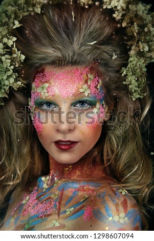 close up portrait of young beautiful girl with flower professional makeup. elf princess with flower crown on head.  Halloween makeup. bright face art. spring fairy of flowers