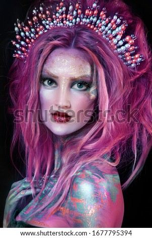 close up  portrait of young beautiful girl with colorful face painting. professional makeup. hair in paint with wreath. beauty portrait. pink hair