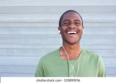 Close Up Portrait Of Young Black Guy Smiling With Earphones