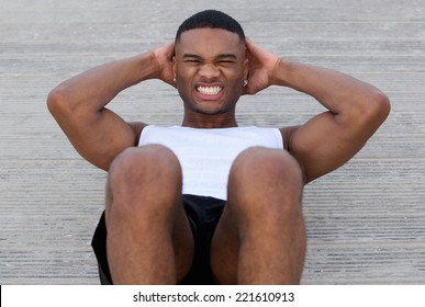 Close up portrait of a young black man doing sit ups  - Powered by Shutterstock