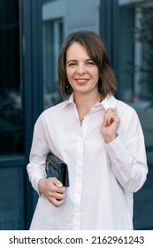 Close up portrait of young business woman in white shirt. Business attire, semi-casual. Vertical frame