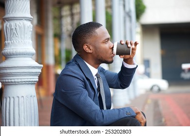 Close up portrait of a young businessman relaxing and drinking coffee in the city