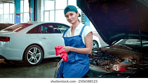 Close up portrait of young Caucasian female wearing working form works at service station smiling at camera. Beautiful woman has just repaired car. - Powered by Shutterstock