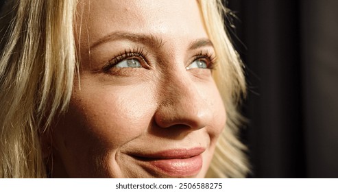 Close up portrait of young Caucasian female with beautiful eyes and smile on face. Pretty woman looks at sun smiling. - Powered by Shutterstock