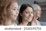 Close up portrait of young Caucasian woman pose with little teen daughter and old mother. Happy three generations of women look in distance visualize future together, show family unity bonding.