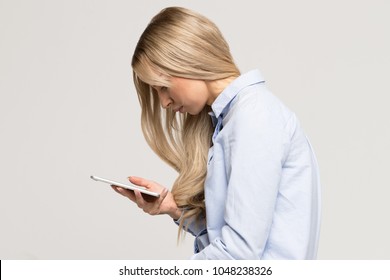Close up portrait of young Caucasian woman looking and using smart phone with scoliosis, side view/Rachiocampsis/Kyphosis curvature of the spine/Incorrect posture, scoliosis, 
orthopedics concept