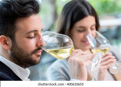 Close Up Portrait Of Young Couple Tasting White Wine Tasting.