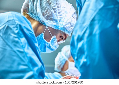 Close Up Portrait Of Young Female Surgeon Doctor Wearing Protective Mask And Hat During The Operation. Healthcare, Medical Education, Surgery Concept