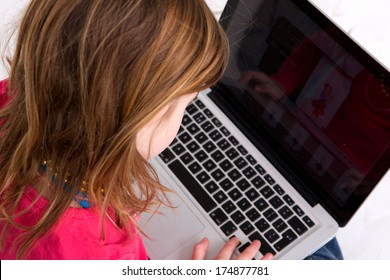 Close Up Portrait Of A Young Girl Looking At Laptop Screen - From Behind