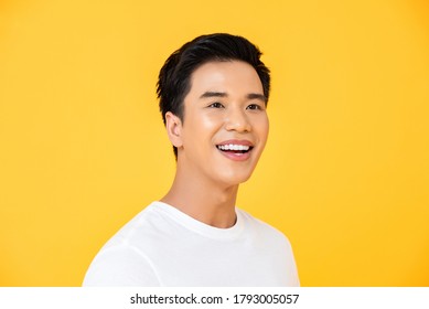 Close Up Portrait Of Young Handsome Asian Man Cheerfuly Smiling And Looking Away In Isolated Studio Yellow Background