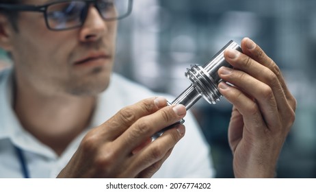 Close Up Portrait of Young Handsome Engineer in Glasses Working on Manufacturing Metal Parts in Office at Car Assembly Plant. Industrial Product Designer Examining Prototype Parts Before Production. - Shutterstock ID 2076774202