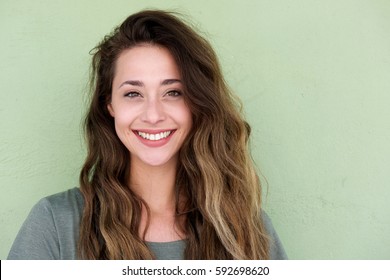 Close up portrait of young happy woman on green background