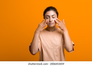 Close up portrait of young indian american woman doing facebuilding yoga face gymnastics yoga self massage - Powered by Shutterstock